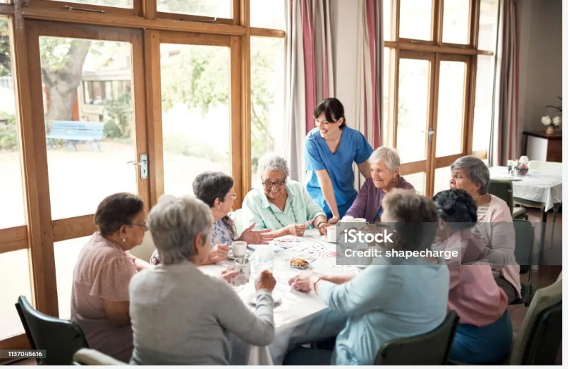Senior woman walking arm-in-arm with a staff member outside her assisted living facility